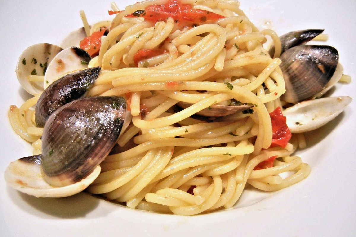 Spaghetti al cartoccio: profumi di mare con vongole, cozze, capesante e mandorle croccanti